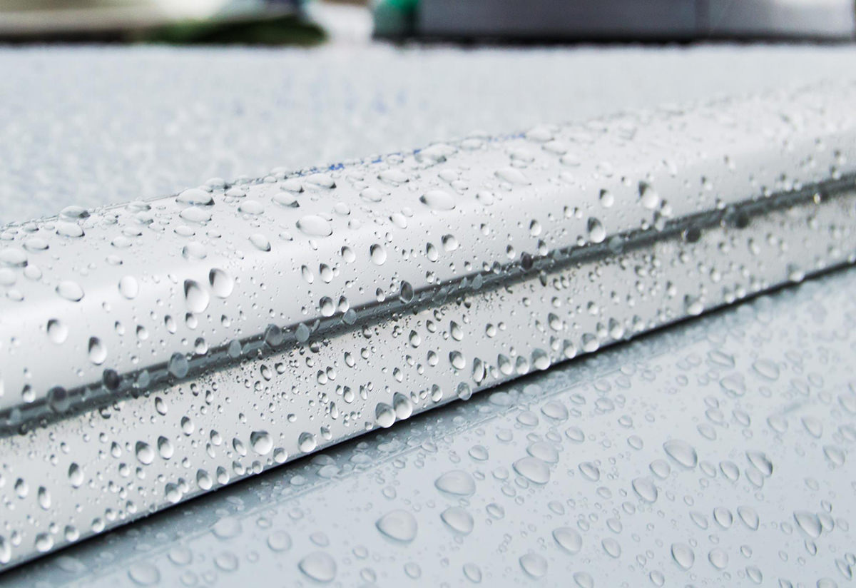 Gotas de gelo derretido sobre o tejadilho de um carro cinzento