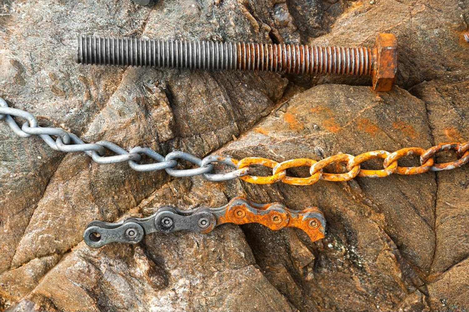 Parafuso, corrente e corrente de bicicleta oxidados na parte direita da imagem e sem ferrugem na parte esquerda