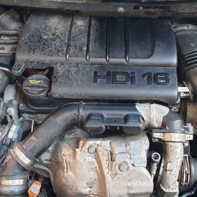 Motor HDi 16 de un coche, mostrando acumulación de polvo y suciedad en las superficies, antes de una limpieza detallada.